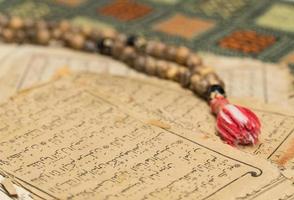 Muslim prayer beads with ancient pages from the Koran. Islamic and Muslim concepts. Ancient old sheets of paper from the Arabic book photo