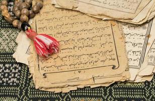 Muslim prayer beads with ancient pages from the Koran. Islamic and Muslim concepts. Ancient old sheets of paper from the Arabic book photo