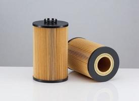 two automotive filter cylindrical shape of orange color on a white background