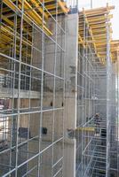 builder performs work standing on high scaffolding photo