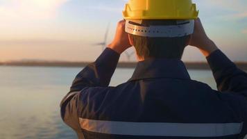 A male engineer wearing a protective helmet at sunset. video