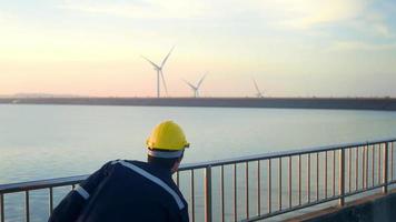 un ingeniero que lleva un casco protector al atardecer. video