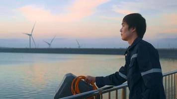 un ingeniero que lleva un casco protector al atardecer. video