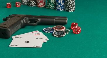 Poker chips, cards and gun on a green background. The concept of gambling and entertainment. Casino and poker photo