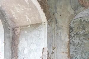 interior view of an abandoned old building with an arch in the wall photo