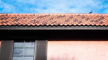 roof top on sky background. Close up of brown clay roof tiles. Red old dirty roof. Old roof tiles. Close-up aerial view of the traditional red Mediterranean roofs with blue summer sky in the old town photo