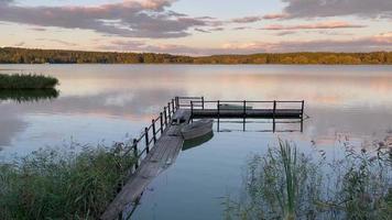 oude pier aan het rustige meer met zonsondergang video