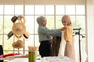 ambas mujeres musulmanas tienen un pequeño negocio en sus propios hogares. es el diseño y confección de ropa.