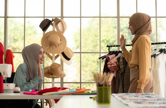 ambas mujeres musulmanas tienen un pequeño negocio en sus propios hogares. es el diseño y confección de ropa. foto