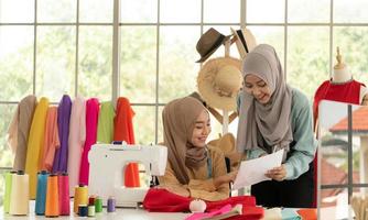 ambas mujeres musulmanas tienen un pequeño negocio en sus propios hogares. es el diseño y confección de ropa.