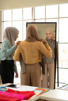 ambas mujeres musulmanas tienen un pequeño negocio en sus propios hogares. es el diseño y confección de ropa. foto