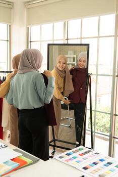 ambas mujeres musulmanas tienen un pequeño negocio en sus propios hogares. es el diseño y confección de ropa. foto
