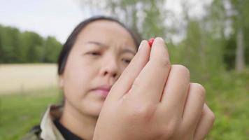 närbild asiatisk kvinna som håller ett frö i handen i skogen video