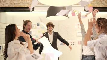 Happiness young multiracial coworker's team celebrates business success with Caucasian boss by throwing papers and clapping, cheerful when the meeting finishes in an office's conference workplace. video