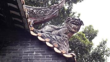 Cerca de una escultura de león dragón decorar en un techo de una antigua arquitectura de tradición china en la antigua ciudad de Shawan, Guangzhou, China foto
