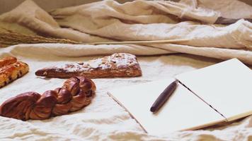 panes y tostadas para el desayuno y libro de notas sobre fondo de sábanas blancas, desayuno saludable. fondo de idea de concepto de estilo de vida de salud por la mañana