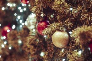 árbol de navidad decorado sobre fondo borroso. Decoración navideña. Colgando bolas rojas en ramas de pino, guirnaldas de árboles de Navidad y adornos sobre fondo abstracto bokeh con espacio de copia foto