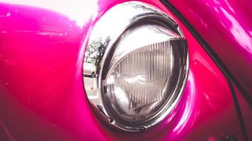 Close-up of headlights of pink  vintage retro beautiful vehicle car photo