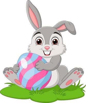 Cartoon little rabbit holding easter egg in the grass