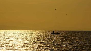 fiskebåt siluett i havet och solnedgången video