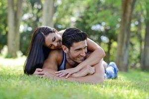 Happy smiling couple laying on green grass
