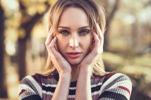 Close-up portrait of young blonde woman with blue eyes photo