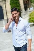 Handsome man in urban background talking on phone photo