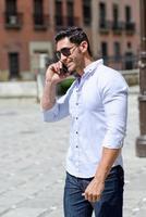 Handsome man in urban background talking on phone photo