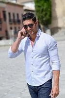 Handsome man in urban background talking on phone photo