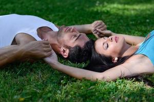 Happy smiling couple laying on green grass photo