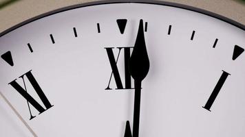 el reloj de pared blanco indica la hora a las 12 en punto. es hora de relajarse y almorzar. video