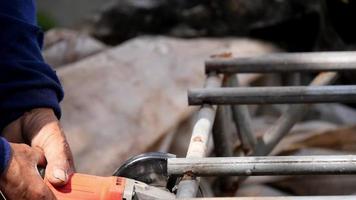 Metal worker is using  steel cutter. To break the iron in half. video