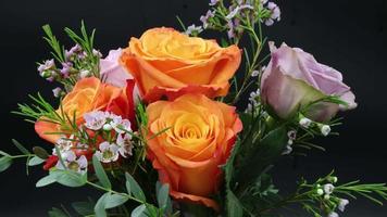 Time-Lapse Of Opening To Dying Orange And Purple Roses And Wax Flowers On Black video