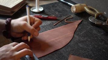 Lederfabrik Herstellung handgefertigtes Notizbuch - Nahaufnahme Hände arbeiten