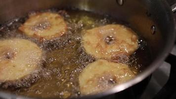 maçãs em massa, fritas na panela em óleo fervente. video