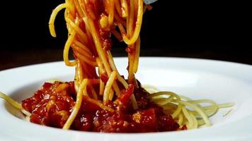 Close up, Spaghetti and tomato sauce on the plate. long spaghetti with fork. video