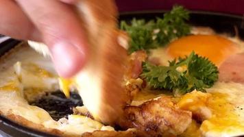 uomo che mangia colazione tradizionale con uova fritte, pane tostato e insalata video