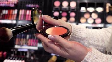plank met cosmetica - lippenstift, oogschaduw - vrouw winkelen in een winkelcentrum