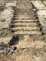 step stone staircase in the ruins of the ancient cave city, old stairs close up, Stone staircase with plants in a medieval city with cobblestone. photo