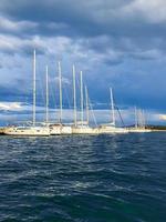 puerto de veleros, muchos hermosos yates de vela amarrados en el puerto marítimo, transporte acuático moderno, vacaciones de verano, estilo de vida de lujo y concepto de riqueza. foto