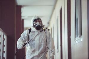 Medical staff wearing PPE spraying disinfectant against the spread of the virus photo