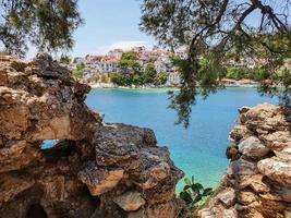 View through ruins of stones to the old part of the town of Skiathos on Skiathos island, Greece.
