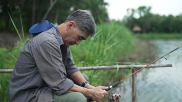Senior man holding hook fishing in river video
