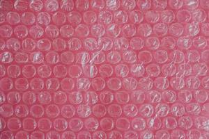 Packaging with air bubbles on a pink background. Bubble wrap texture, packaging, air bubble film. Top view. Copy, empty space for text photo