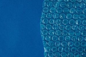 Packaging with air bubbles on a blue background. Bubble wrap texture, packaging, air bubble film. Top view. Copy, empty space for text