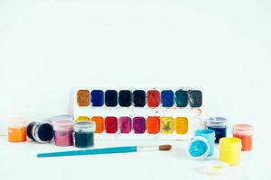 Set of colorful gouache paints with a brush on a white background photo