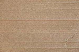 Crumpled corrugated cardboard surface texture background. Seamless crumpled brown paper textured backdrop. Top view. Copy, empty space for text photo