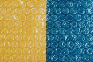 Packaging with air bubbles on a yellow and blue background. Bubble wrap texture, packaging, air bubble film. Copy, empty space for text photo