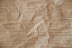 Crumpled corrugated cardboard surface texture background. Seamless crumpled brown paper textured backdrop. Top view. Copy, empty space for text photo