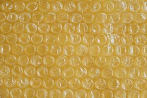 Packaging with air bubbles on a yellow background. Bubble wrap texture, packaging, air bubble film. Top view. Copy, empty space for text photo